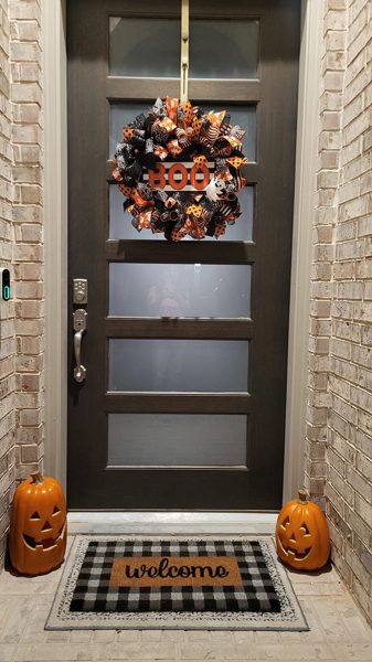 Customer's Halloween wreath on a porch with pumpkins